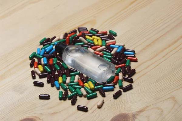 Ayurvedic vitamin capsule, ayurvedic oil bottle on wooden background.