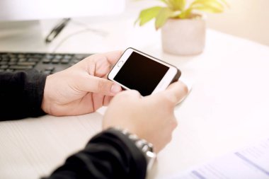 Adam elinde bir telefon tutuyor.