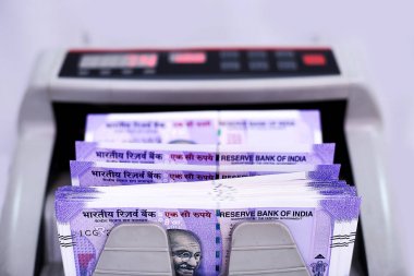Yeni 100 rupilik banknotlarla elektronik para sayacı. Beyaz arka planda yalıtılmış.