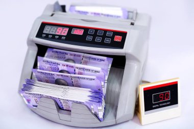 Nakit sayma makinesinde yeni Hint para birimi notları. Beyaz arka planda yalıtılmış.