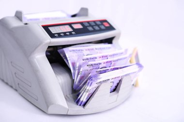 Nakit mevduat makinesinde yeni Hint parası. banka ofisi veya döviz döviz elektronik para sayaç makinesi. Beyaz arka planda yalıtılmış.