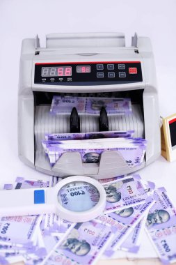 Yeni Hint para birimi, nakit sayma makinesi ve büyüteç portresi. Beyaz arka planda yalıtılmış.