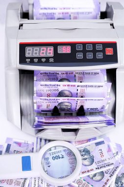 Yeni Hint para birimi saymak için para sayma makinesi. Büyüteç resmi. Beyaz arka planda yalıtılmış.