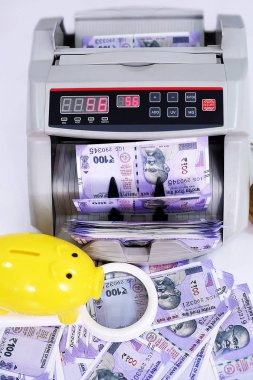 Yeni Hint para birimi, nakit sayma makinesi, büyüteç ve kumbara portresi. Beyaz arka planda yalıtılmış.