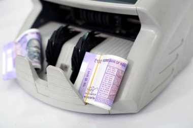 Para sayma makinesinde 100 rupi lik banknot. Beyaz arka planda yalıtılmış.