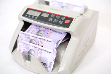 Para sayma makinesinde Hint banknotu. Beyaz arka planda yalıtılmış.