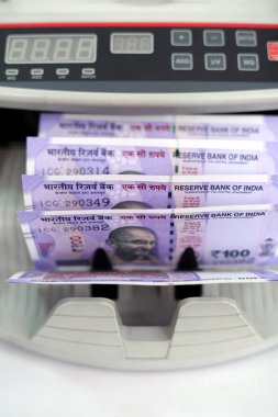 Banknot sayacı ve yeni Hint banknotları. Beyaz arka planda yalıtılmış.