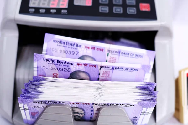 Money counting machine with new Indian currency. Isolated on the white background.