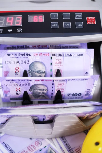 Kumbaralı sayma makinesindeki banknot. Beyaz arka planda yalıtılmış.