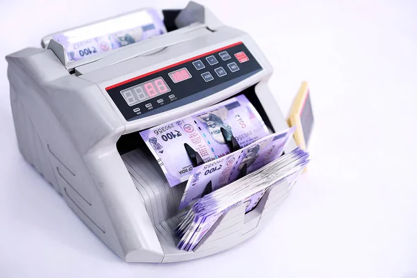 Banknot sayacı Hint banknotlarını sayıyor. Beyaz arka planda yalıtılmış.