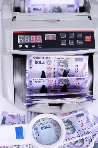 Yeni Hint para birimi, nakit sayma makinesi ve büyüteç resmi. Beyaz arka planda yalıtılmış.
