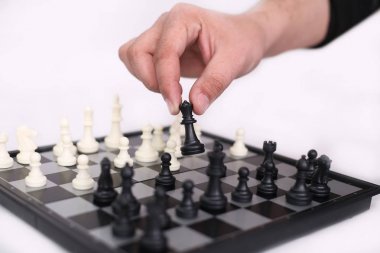 İnsan portresi satranç oynuyor ve elinde piyon tutun. Beyaz arka planda yalıtılmış.