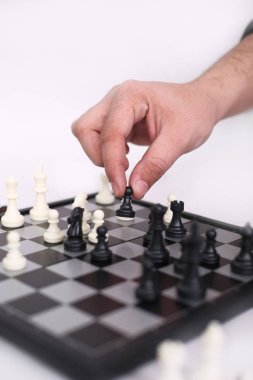 Adam eli satranç oynuyor. Beyaz arka planda yalıtılmış.