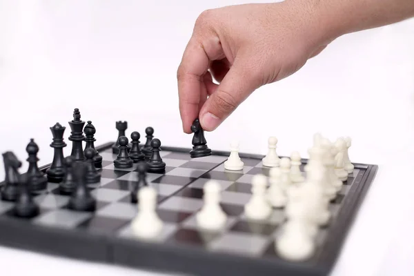 Man is playing chess and hold pawn. Isolated on the white background.