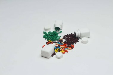 Şişe ile farklı ayurveda vitamin kapsülü. Beyaz arka planda yalıtılmış.