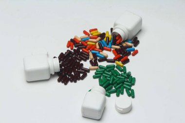 Şişe ile farklı ayurveda vitamin kapsülü. Beyaz arka planda yalıtılmış.