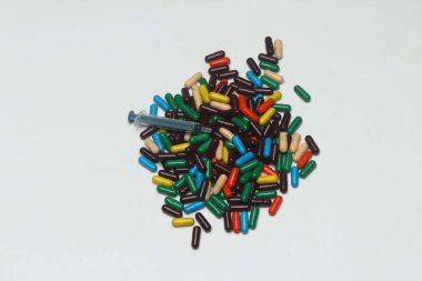 Enjeksiyon şırınga ile Ayurveda renkli vitamin kapsülü. Beyaz arka planda yalıtılmış.