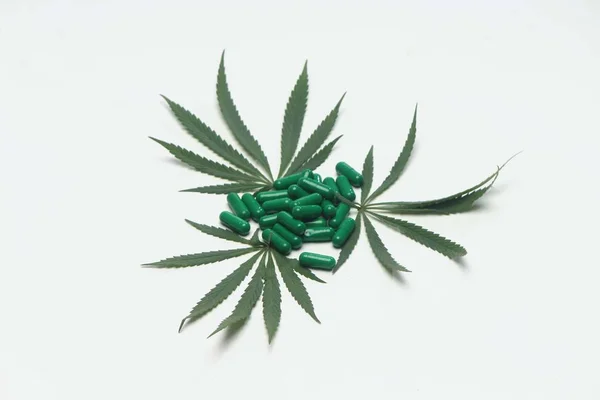 マリファナの葉とアーユルヴェーダの緑の錠剤の装飾 白い背景に隔離 — ストック写真