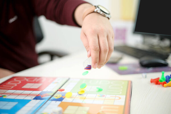 Man started playing ludo game. Isolated on white background.