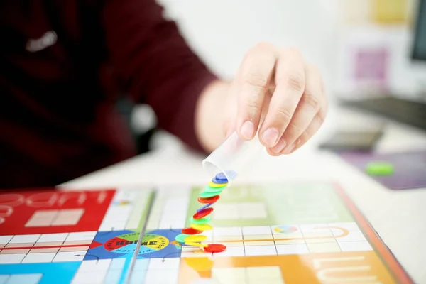 Man started playing ludo game. Isolated on white background.