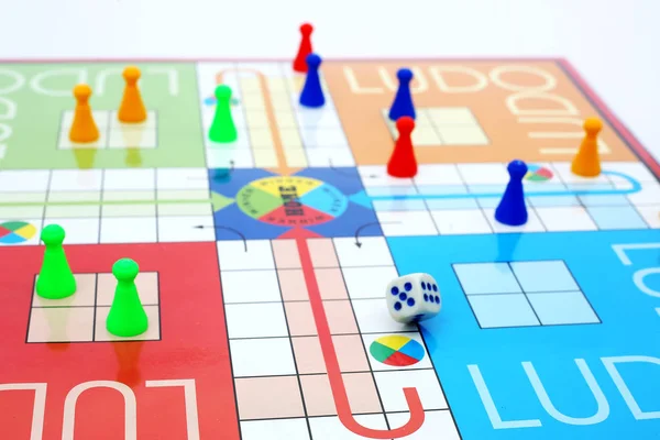 Picture of different color tokens with dice on ludo.  Isolated on white background.