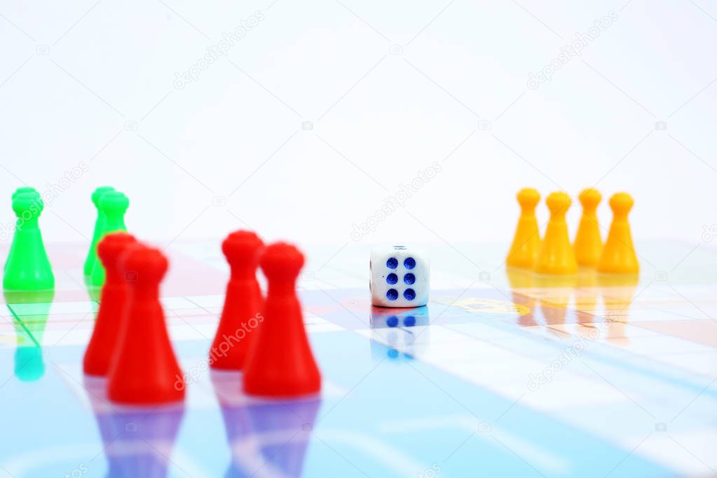   Picture of different colored tokens with dice on ludo.  Isolated on white background.