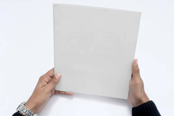 Erkek elinin resmi boş bir dergi tutuyor. Beyaz arka planda yalıtılmış.