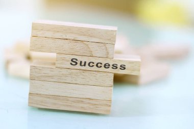 Başarı kelimesi ahşap blok üzerine yazılmış. Tasarım, konsept için ahşap masa üzerinde başarı metni.