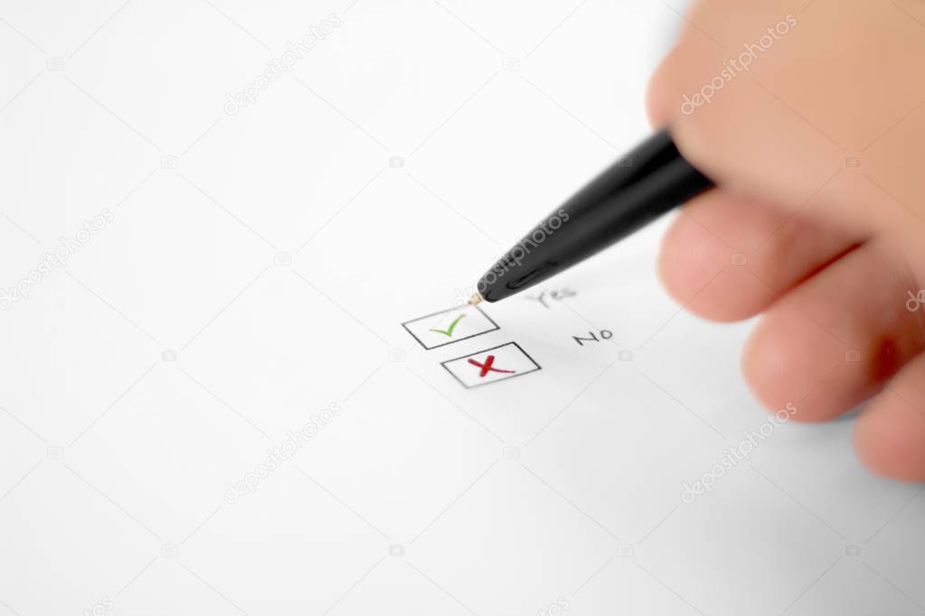 Picture of man writing on paper Yes or No boxes. Isolated on white background.