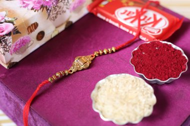 Hint festivali: Raksha Bandhan özgeçmişi zarif bir Rakhi, pirinç taneleri ve Kumkum ile. Geleneksel Hint bilekliği Kardeşler ve Kız Kardeşler arasındaki aşkın sembolüdür..