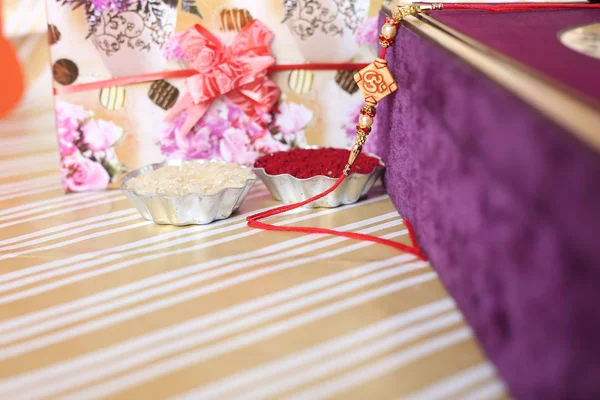 Hint festivali: Raksha Bandhan özgeçmişi zarif bir Rakhi, pirinç taneleri ve Kumkum ile. Geleneksel Hint bilekliği Kardeşler ve Kız Kardeşler arasındaki aşkın sembolüdür..