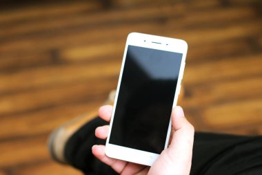 Elinde cep telefonu tutan bir adamın resmi. Beyaz arka planda yalıtılmış.