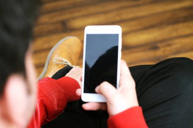 Elinde cep telefonu tutan bir adamın resmi. Beyaz arka planda yalıtılmış.