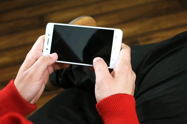 Elinde cep telefonu tutan bir adamın resmi. Beyaz arka planda yalıtılmış.