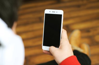 Elinde cep telefonu tutan bir adamın resmi. Beyaz arka planda yalıtılmış.