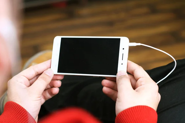 Elinde cep telefonu tutan bir adamın resmi. Beyaz arka planda yalıtılmış.