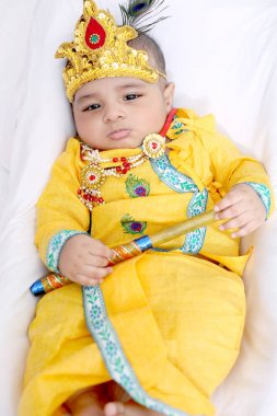 Lord Krishna kostümgiyen ve Janmashtami festivalini kutlayan Hintli Küçük çocuğun resmi. Yalıtılmış beyaz arka plan.