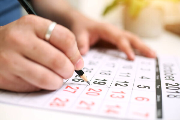 Picture of Man holding Calendar and marking on date. Isolated on white background.