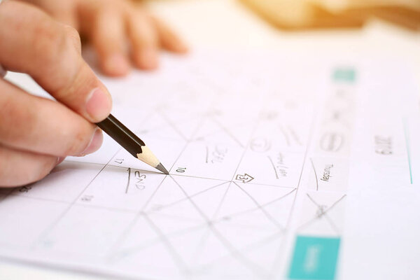 Picture of Man holding Calendar and marking on date. Isolated on white background.