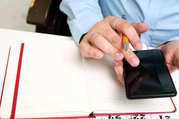 Picture of Man writing on notebook with pen . Isolated on white background.