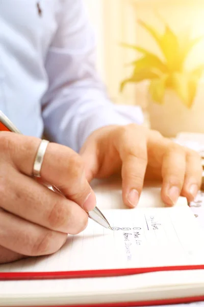 Picture of Man writing on notebook with pen . Isolated on white background.