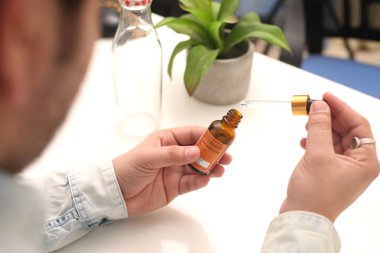 Elinde tutan ilaç şişesini bırakan bir adamın resmi. Beyaz arka planda yalıtılmış.