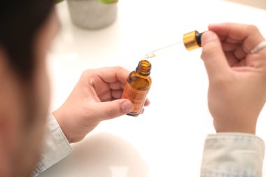 Elinde tutan ilaç şişesini bırakan bir adamın resmi. Beyaz arka planda yalıtılmış.