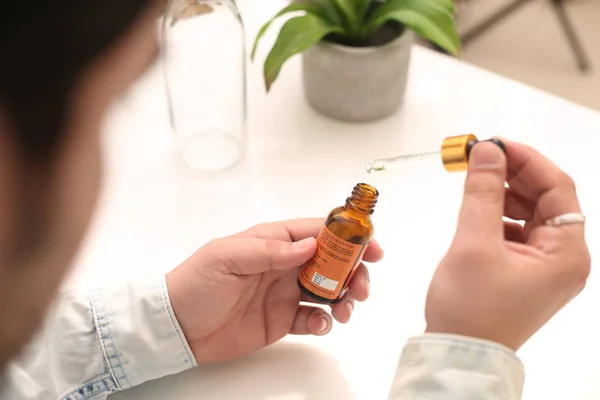 Elinde tutan ilaç şişesini bırakan bir adamın resmi. Beyaz arka planda yalıtılmış.