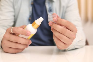 Elinde ilaç şişesi tutan adamın resmi. Beyaz arka planda yalıtılmış.