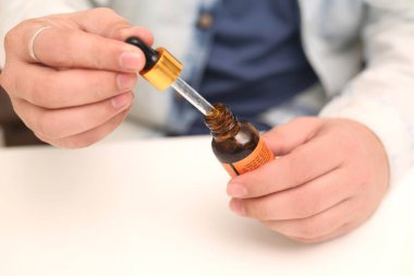 Elinde tutan ilaç şişesini bırakan bir adamın resmi. Beyaz arka planda yalıtılmış.