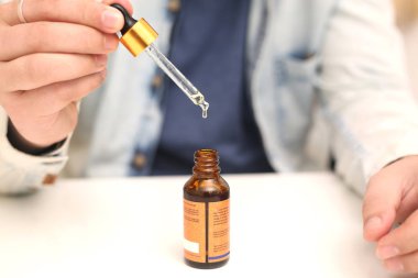 Elinde tutan ilaç şişesini bırakan bir adamın resmi. Beyaz arka planda yalıtılmış.