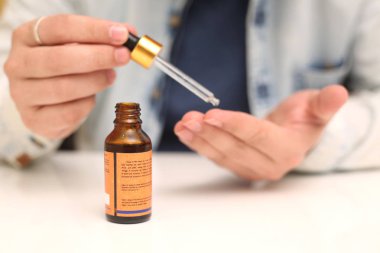 Elinde tutan ilaç şişesini bırakan bir adamın resmi. Beyaz arka planda yalıtılmış.