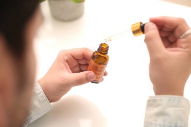 Elinde tutan ilaç şişesini bırakan bir adamın resmi. Beyaz arka planda yalıtılmış.