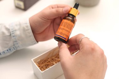 Elinde tutan ilaç şişesini bırakan bir adamın resmi. Beyaz arka planda yalıtılmış.